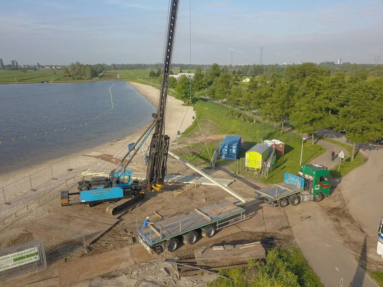 Junttan heistelling bij een strand aan een plas, betonpalen op een oplegger