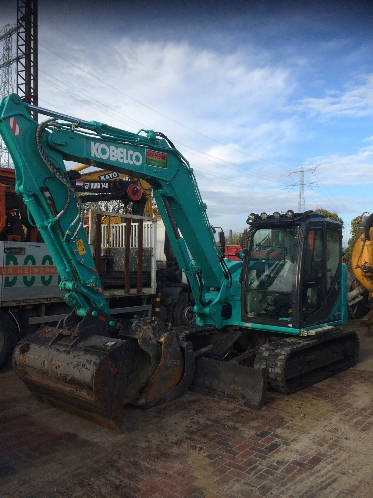 Kobelco midigraver met bak op het eigen terrein