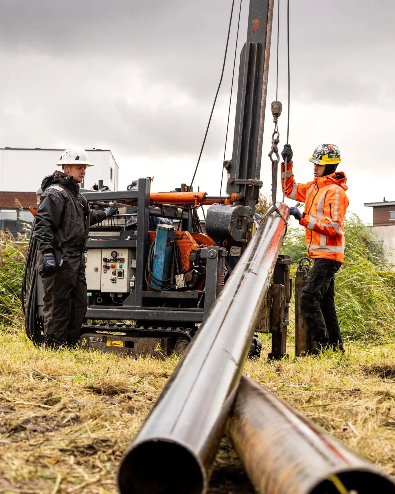 Miniheistelling met twee medewerkers, stalen buispalen in het gras