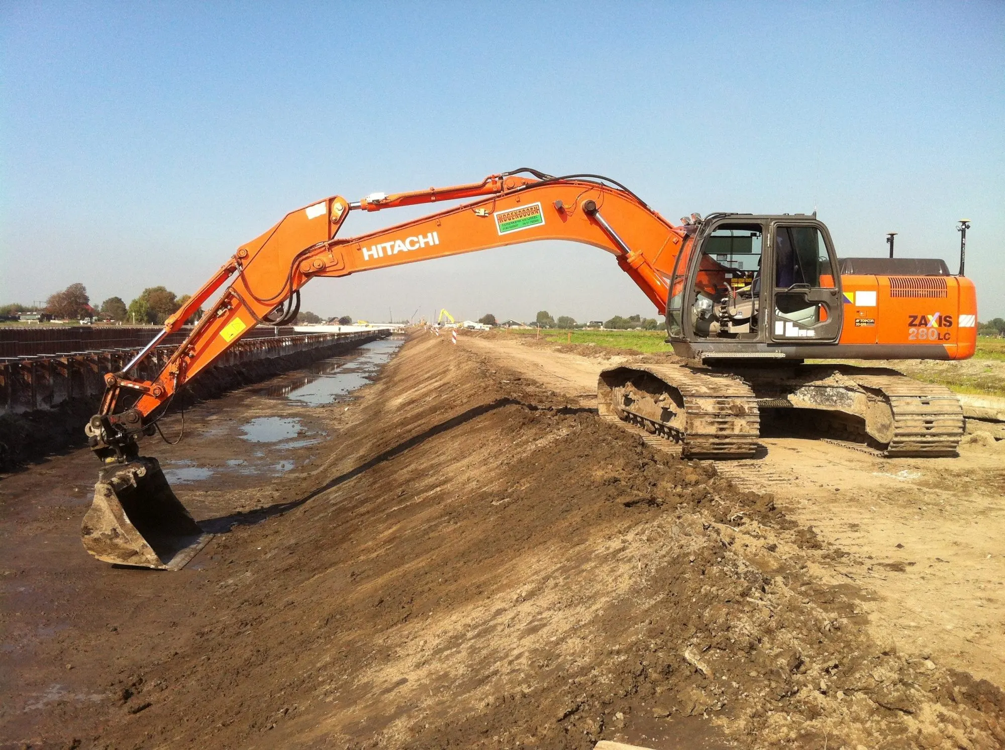 Hitachi ZX280 rupskraan met GPS werkt een talud af langs een sloot