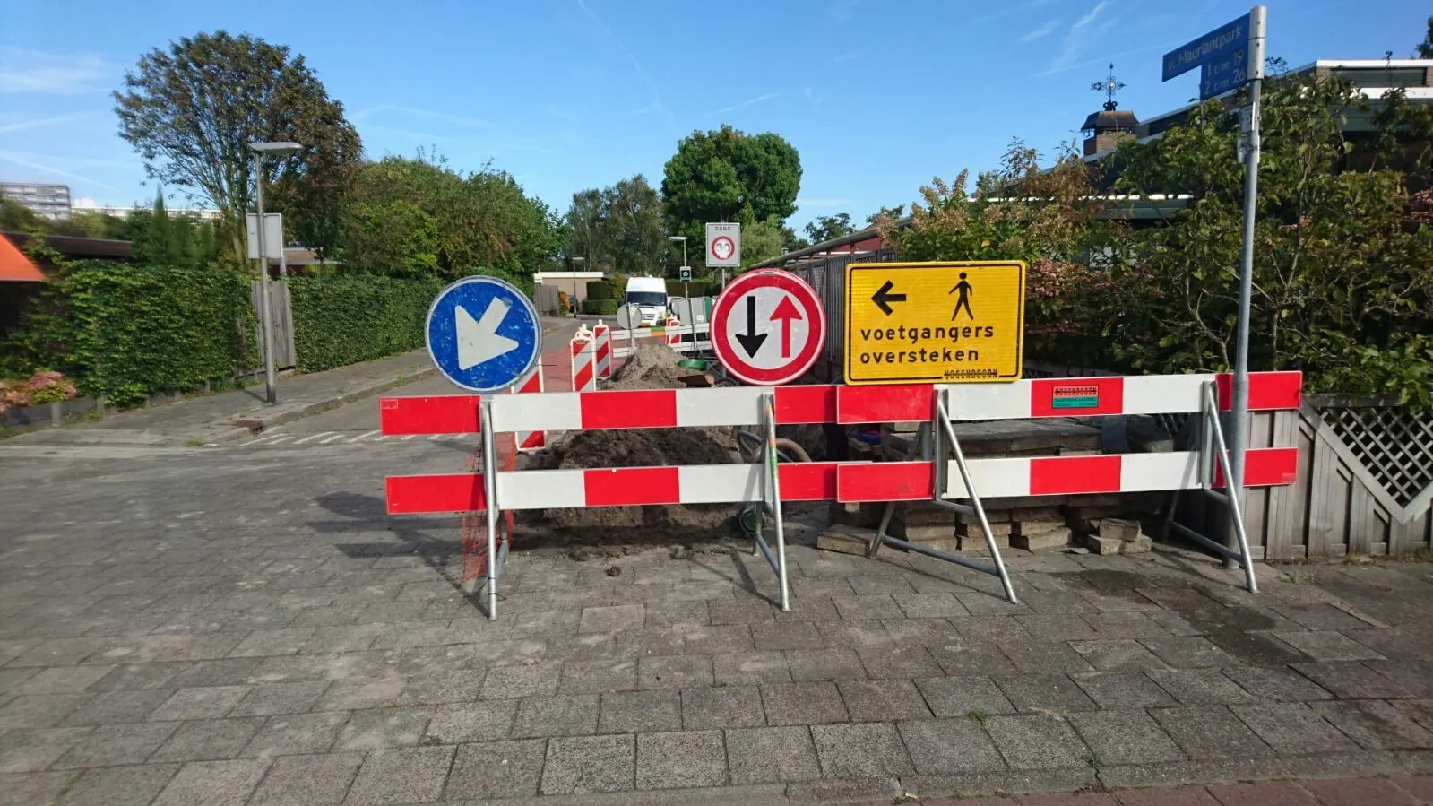 Wegafzetting met rood-witte hekken en verkeersborden